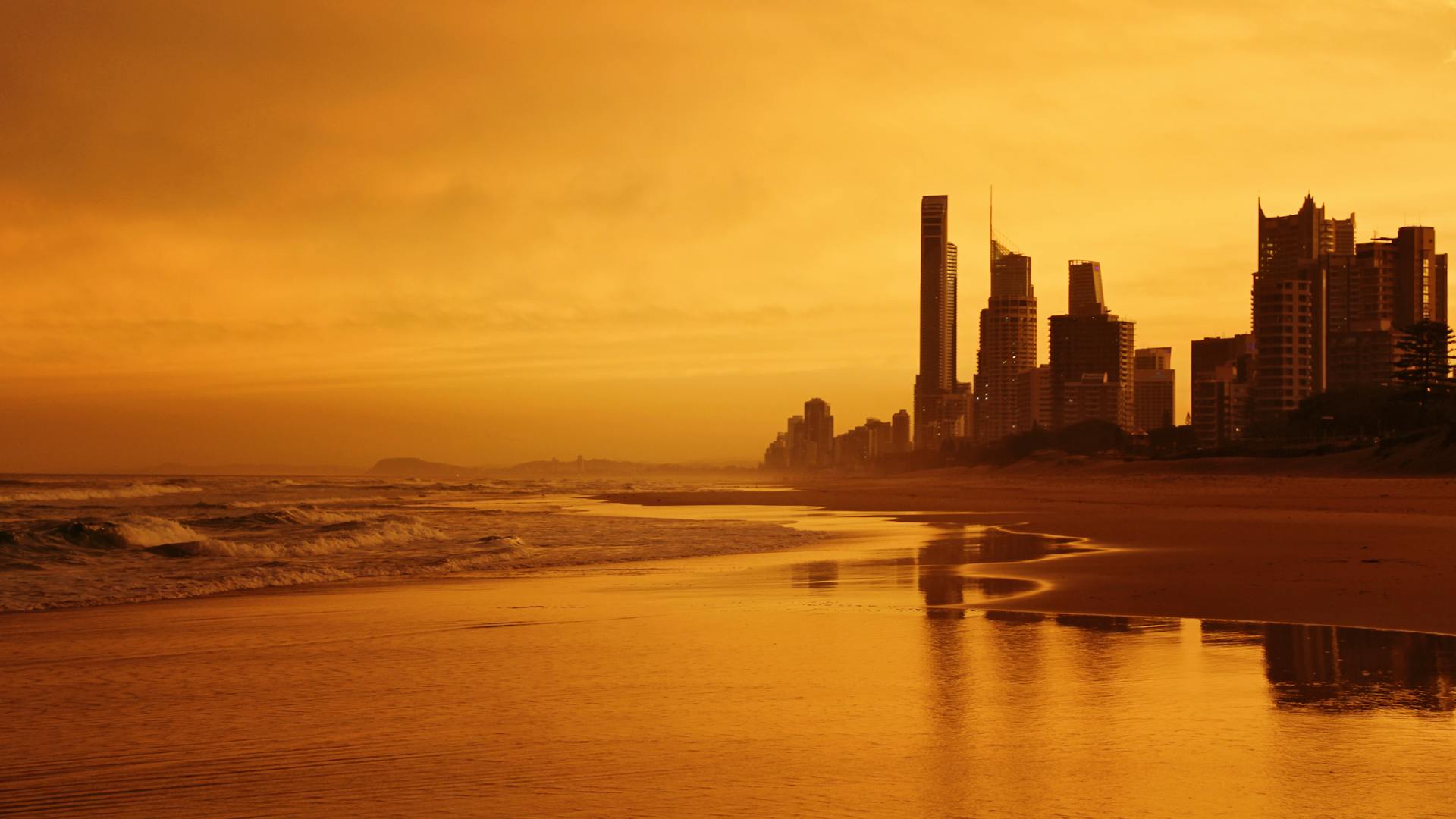 Sunrise and sea waves near high-rise buildings at the Gold Coast.